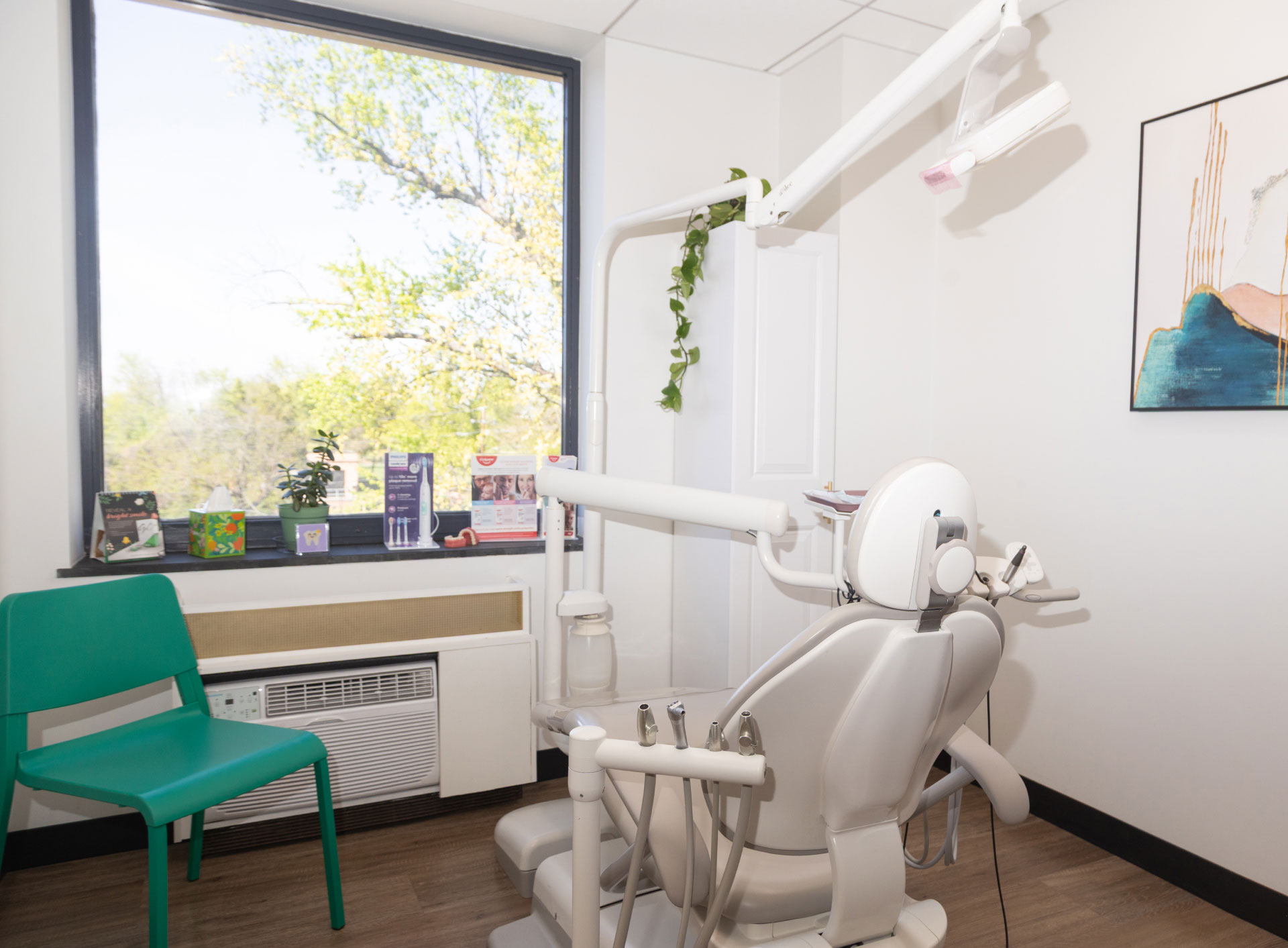 exam room with dental chair and equipment facing window and green chair on left