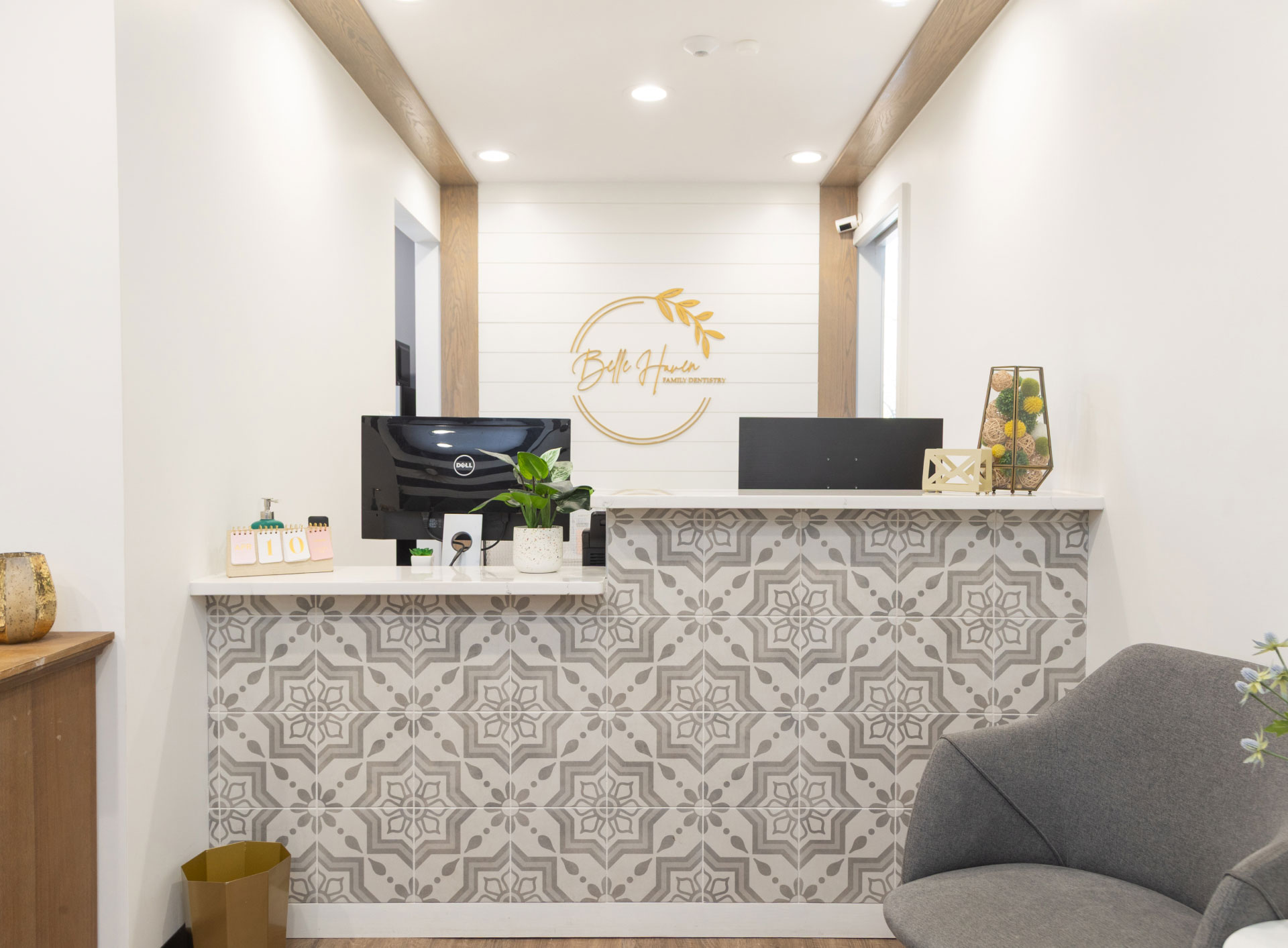 front desk with patterned tile on front and Belle Haven logo on white paneled wall in background