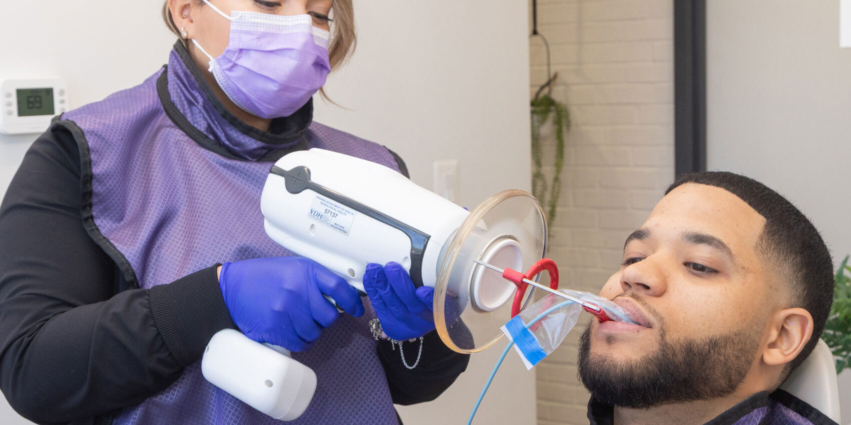 dental assistant using intraoral camera to take xrays of patient's teeth