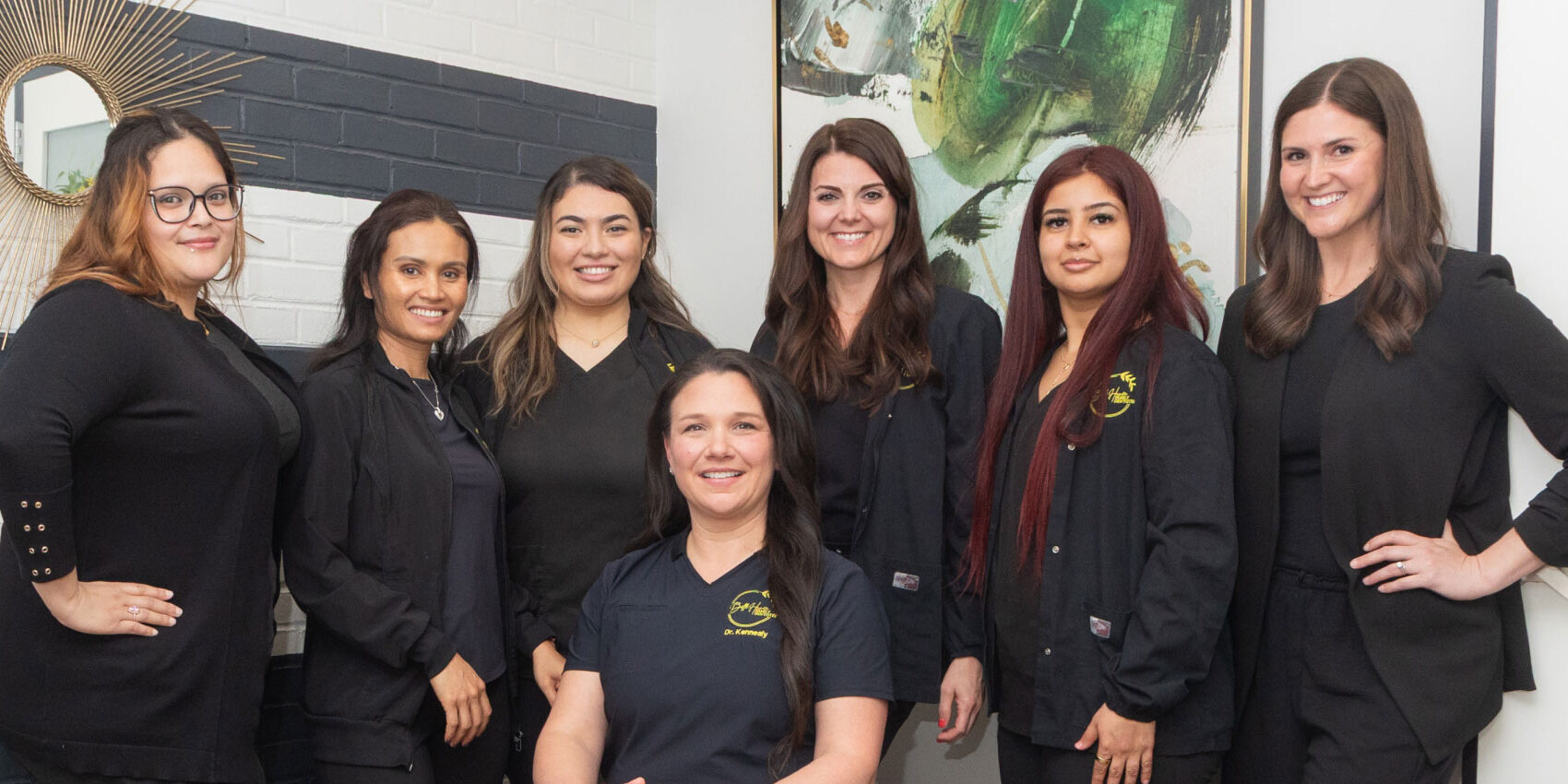 Dr. Kennealy and dental team posing for photo in reception area